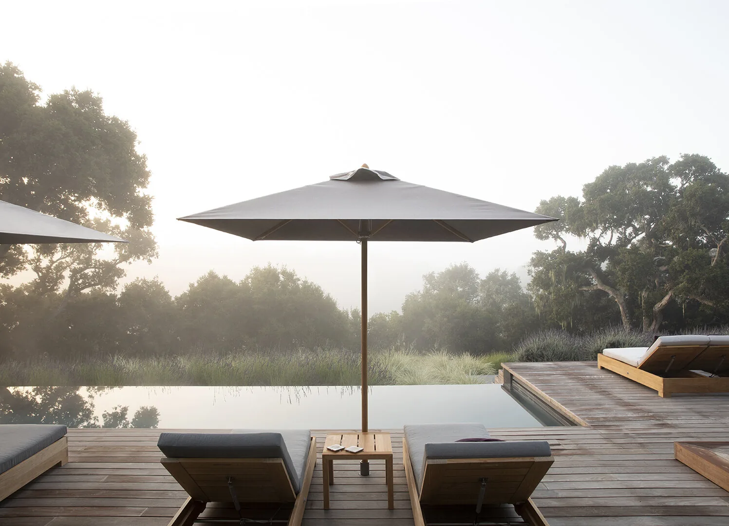 Carmel Contemporary Hacienda — shade umbrella and loungers at the pool's overflow edge