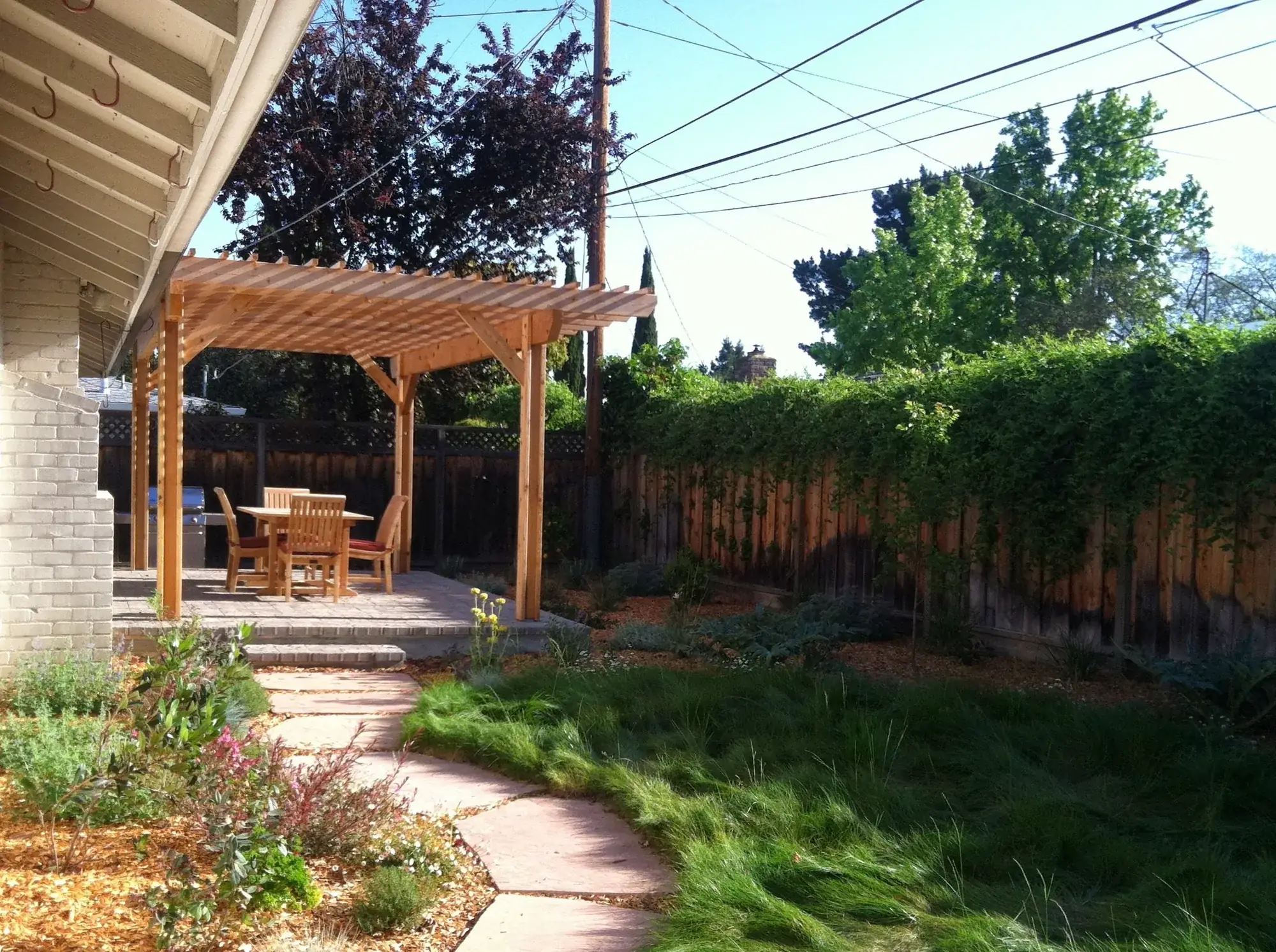 Mountain View Residence — the pergola over the paver dining terrace, with a flagstone path running through the no-mow meadow