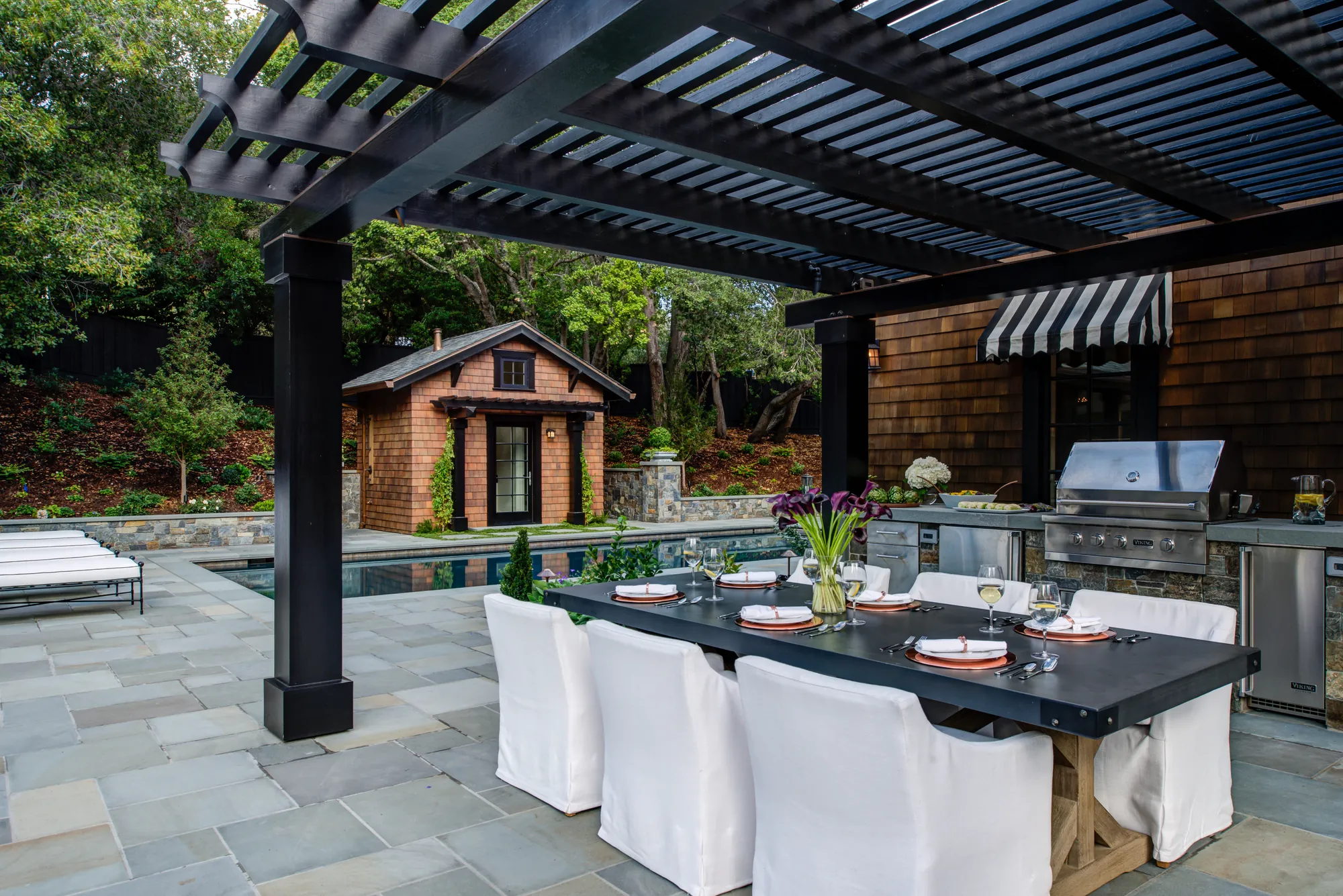 Orinda hillside residence — outdoor kitchen and dining terrace beneath a black pergola