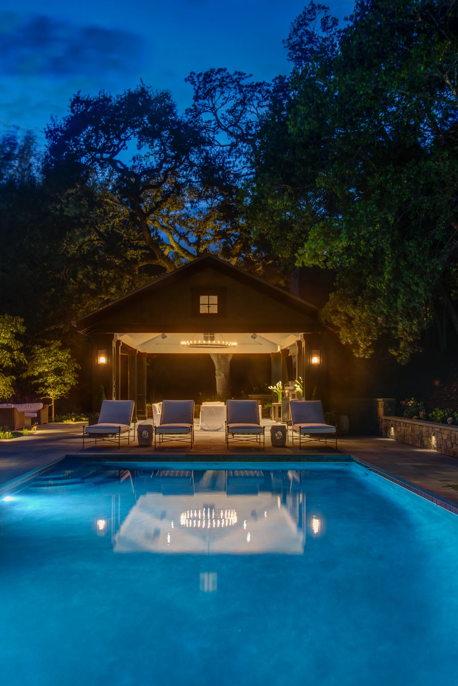 Orinda hillside residence — the pavilion lit at night, reflected the length of the pool